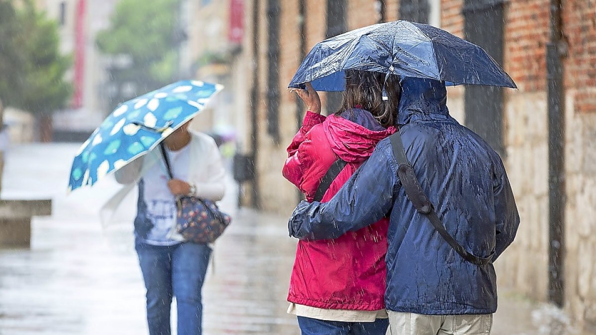 Viandantes pasean bajo la lluvia en Valladolid en una fotografía de archivo.- E. M.