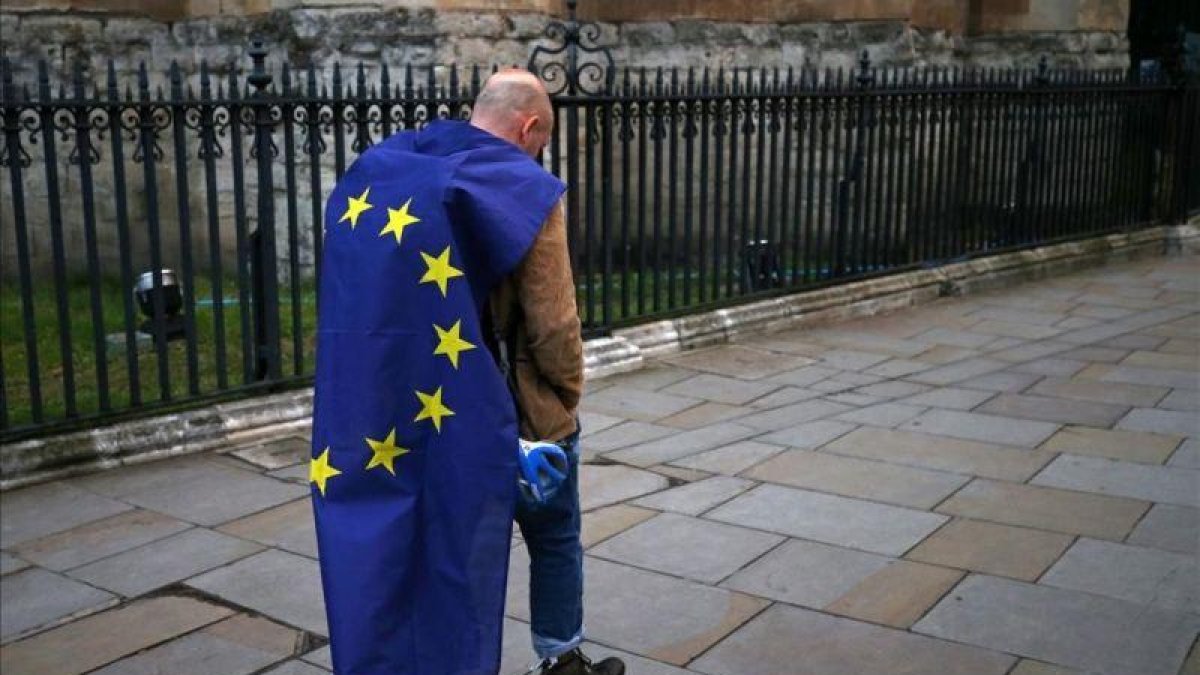 Un manifestante envuelto en una bandera europea en una protesta contra el Brexit en el centro de Londres.-AFP / JUSTIN TALLIS