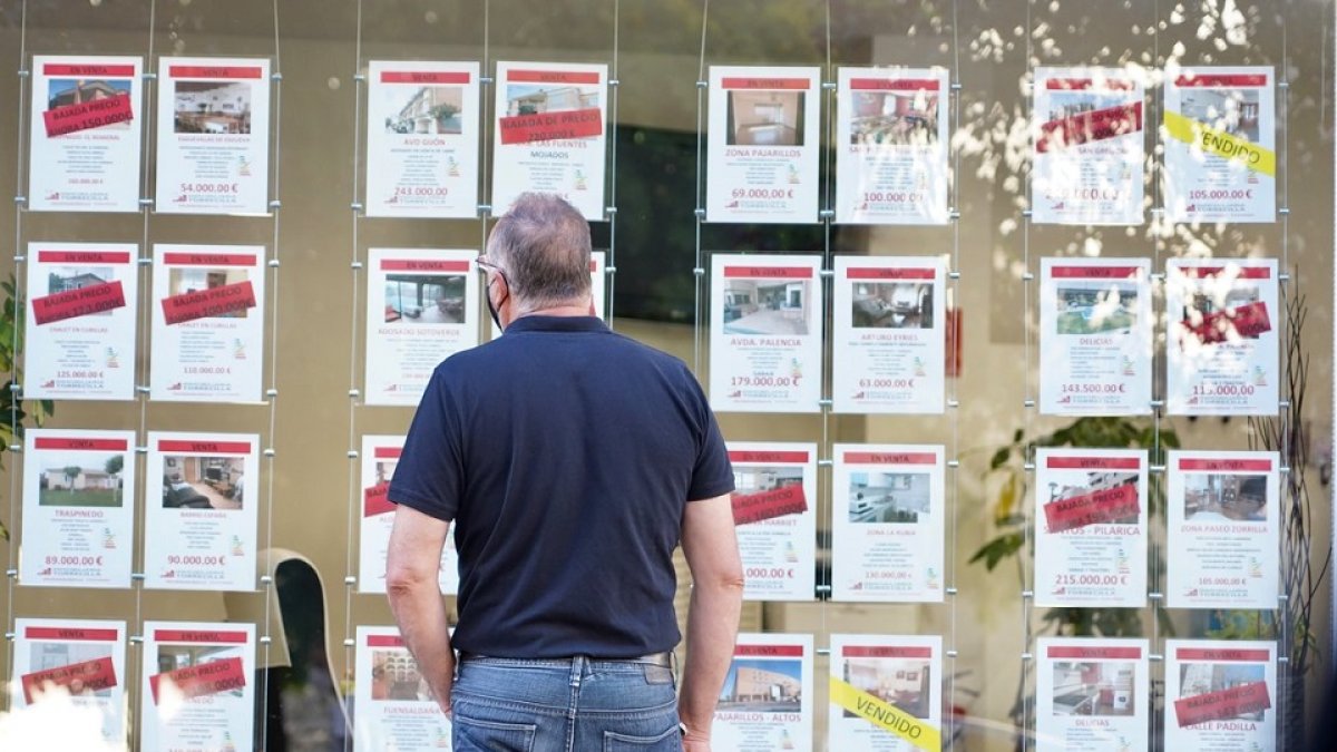 Un hombre observa carteles en el escaparate de una inmobiliaria. ICAL