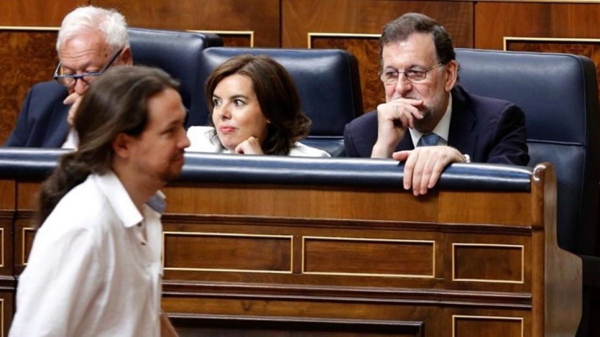 Pablo Iglesias pasa ante Mariano Rajoy mientras se dirige a votar en el acto de constitución de la XII legislatura.-J.M. PRATS