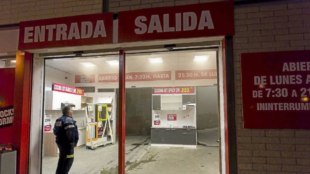 Un policía local vigila la puerta abierta para la salida del humo-Pablo Requejo