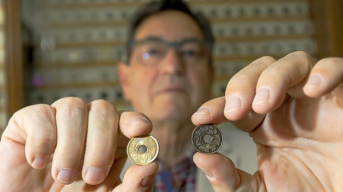 El experto numismático Javier Santos con la moneda buena (d)y la del error, a la izquierda, en la que falta la Y entre Castilla y León.-PABLO REQUEJO (PHOTOGENIC)