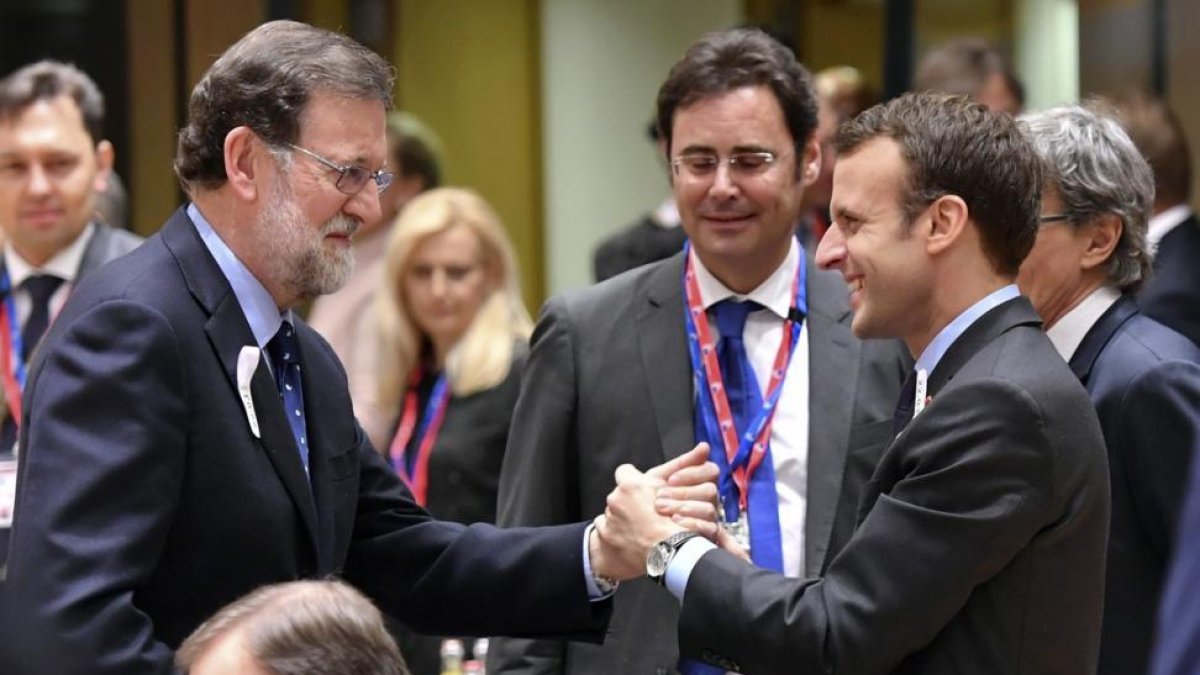Mariano Rajoy saluda al presidente de Francia, Emmanuel Macron, al inicio del Consejo Europeo, este jueves en Bruselas.-/ GEERT VANDEN WIJNGAERT (AP / GEERT VANDEN WIJNGAERT)