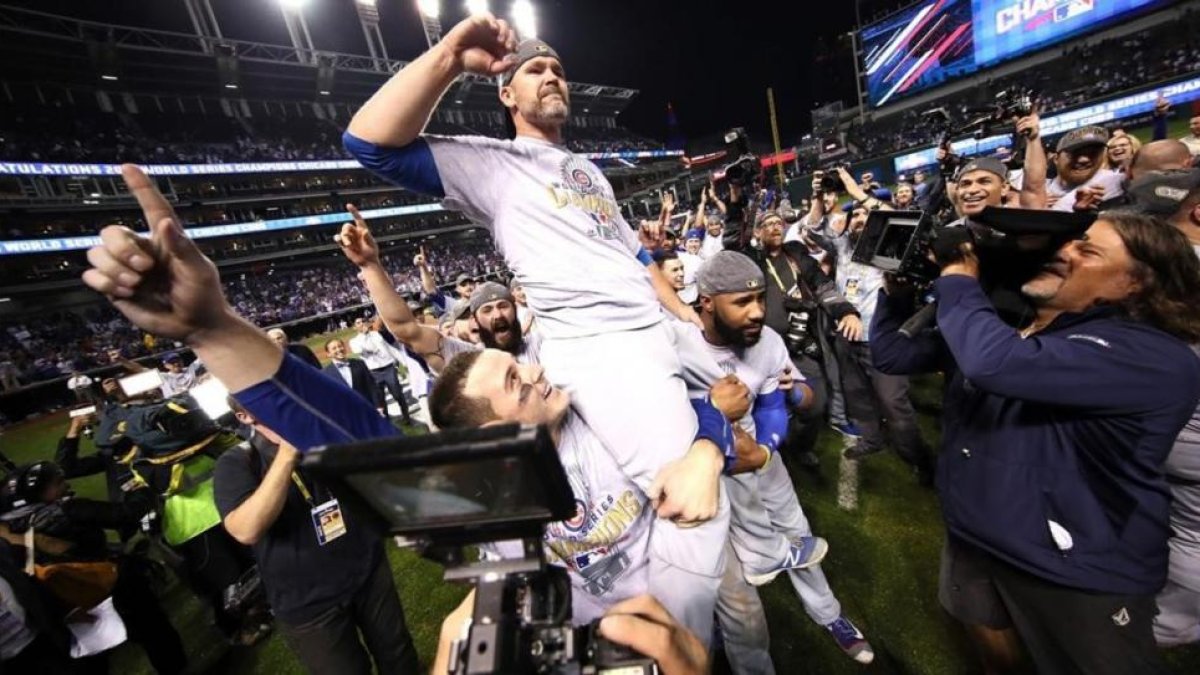 Anthony Rizzo (44), David Ross (3) y Jason Heyward (22) celebran la victoria de los Cubs de Chicago en las Series Mundiales de EEUU.-EZRA SHAW