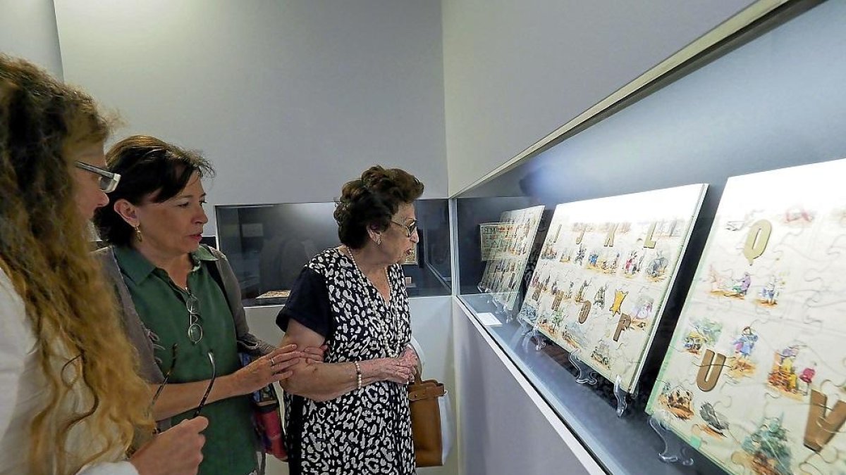 Tres visitantes observan un grupo de paneles que forma parte de la exposición inaugurada ayer en Urueña.-ICAL