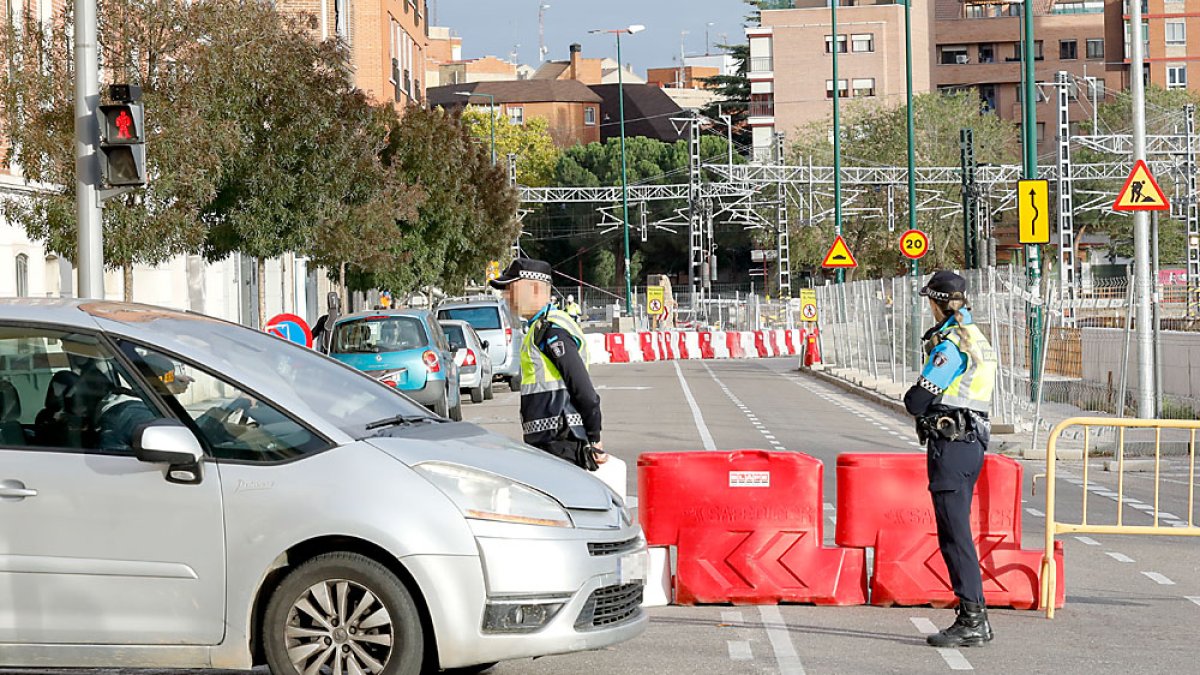 Dos policías municipales controlan el tráfico en la calle Estación, recién cortada. J. M. LOSTAU