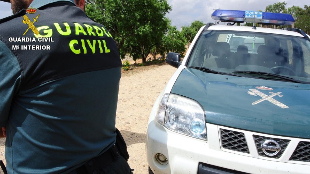 Agente de la Guardia Civil junto a su vehículo - E.M.