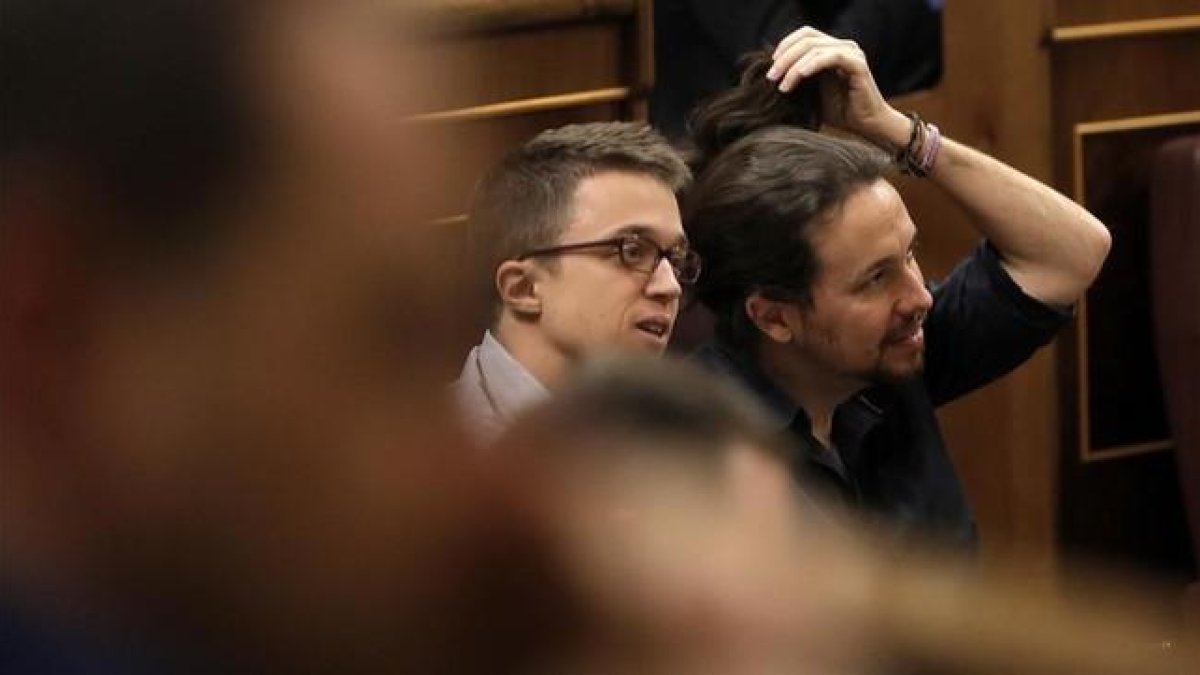 Pablo Iglesias se aregla la coleta mientras escucha el discurso de Sánchez.-JOSÉ LUIS ROCA