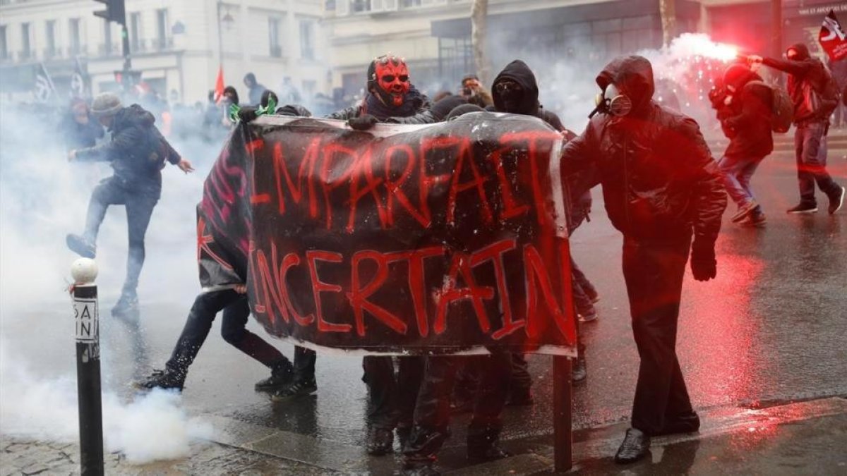 Manifestantes se enfrentan con la policia antidisturbios durante la huelga general en París.-/ EFE / YOAN VALAT