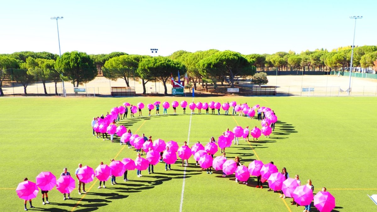 Gran lazo rosa formado con paraguas en Simancas. / E. M.