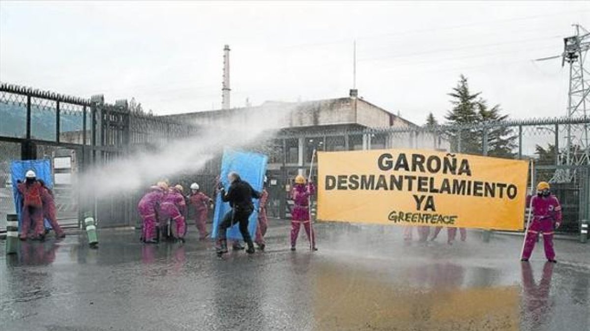 Miembros de Greenpeace reciben manguerazos para evitar su acceso a la central, durante una protesta en Garoña.-