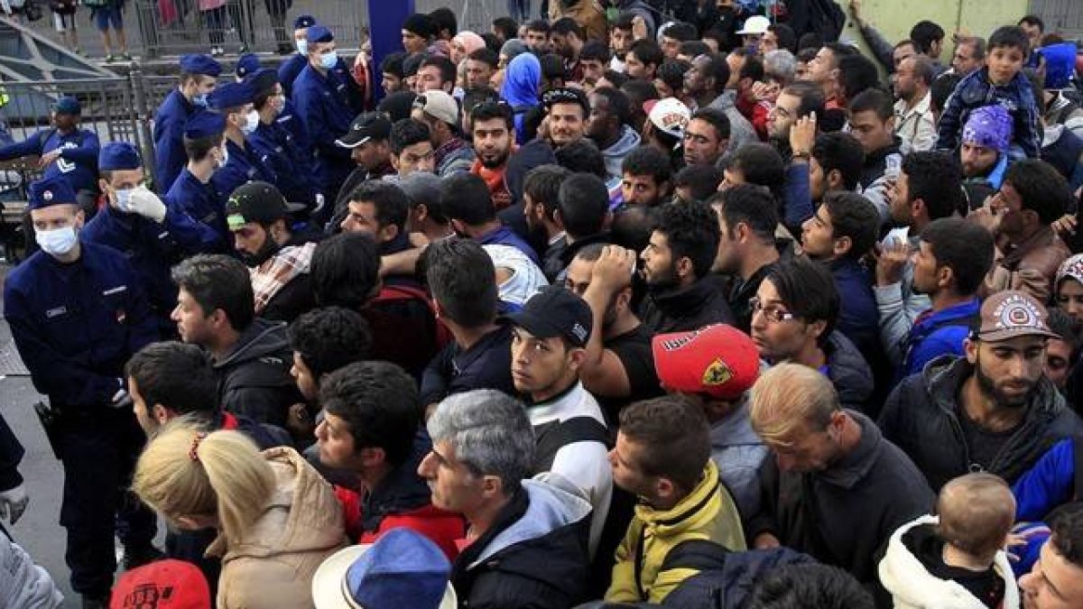 Policías húngaros controlan el acceso a un tren en la estación Keleti, en Budapest, este jueves.-REUTERS / BERNADETT SZABO