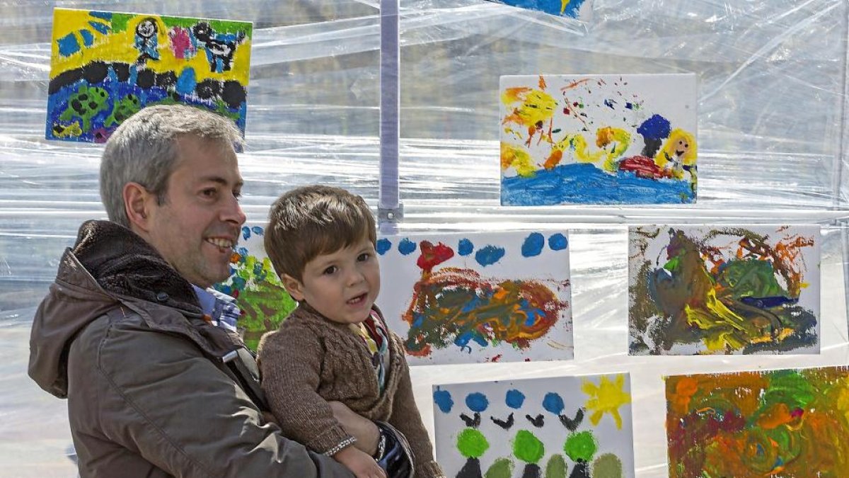 Un padre y su hijo frente al mural que prepararon los pequeños.-MIGUEL ÁNGEL SANTOS