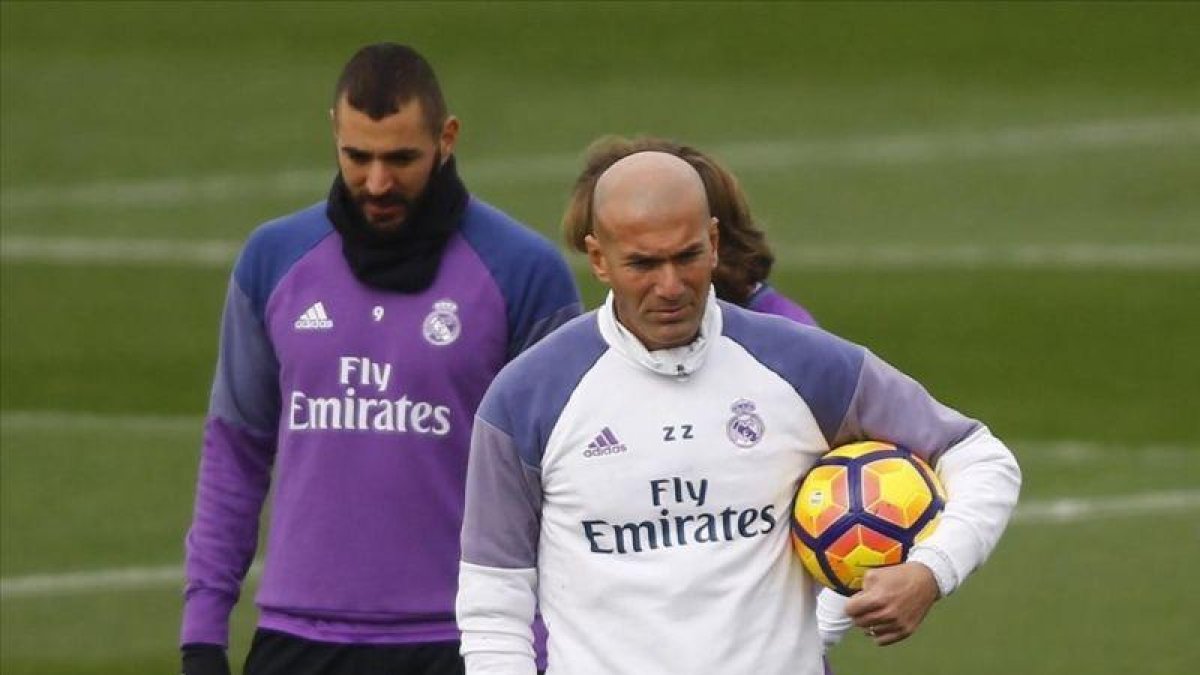 Zinedine Zidane y Karim Benzema, durante el entrenamiento de este viernes en la ciudad deportiva de Valdebebas.-AGUSTIN CATALAN