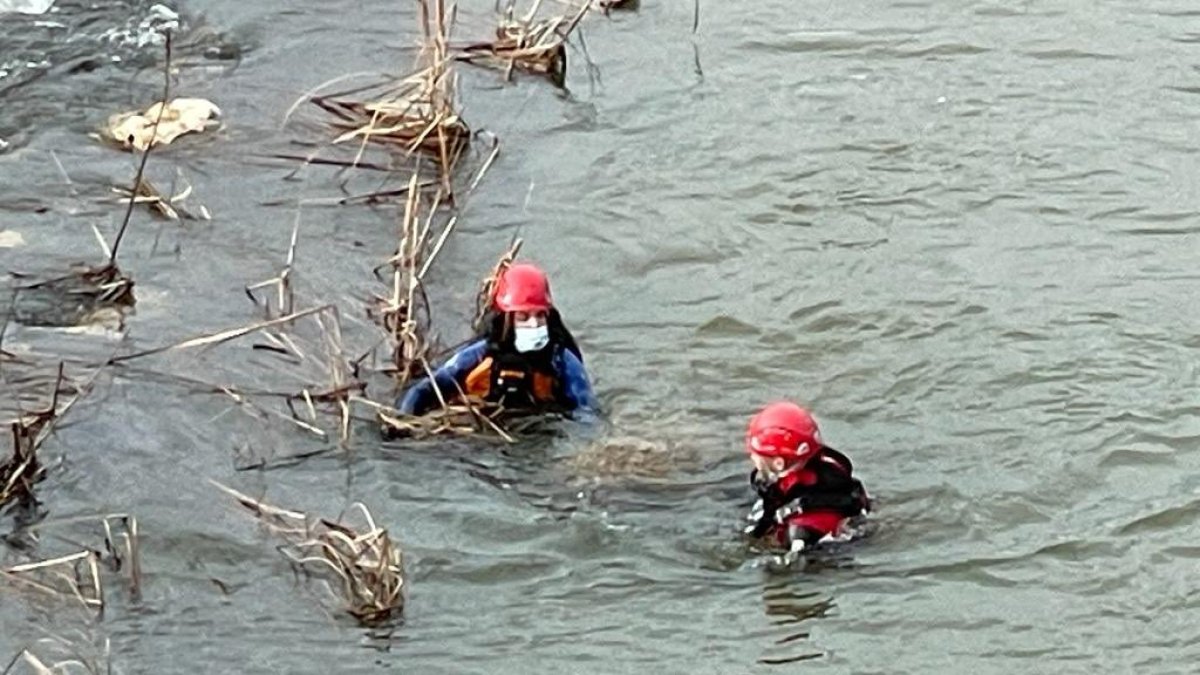 Los bomberos durante el rescate del cadáver en el Duero en Tordesillas. E. M.