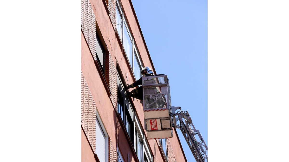 Actuación de los bomberos en la calle Cistérniga para retirar cascotes que caían de la pared de un edificio-ICAL
