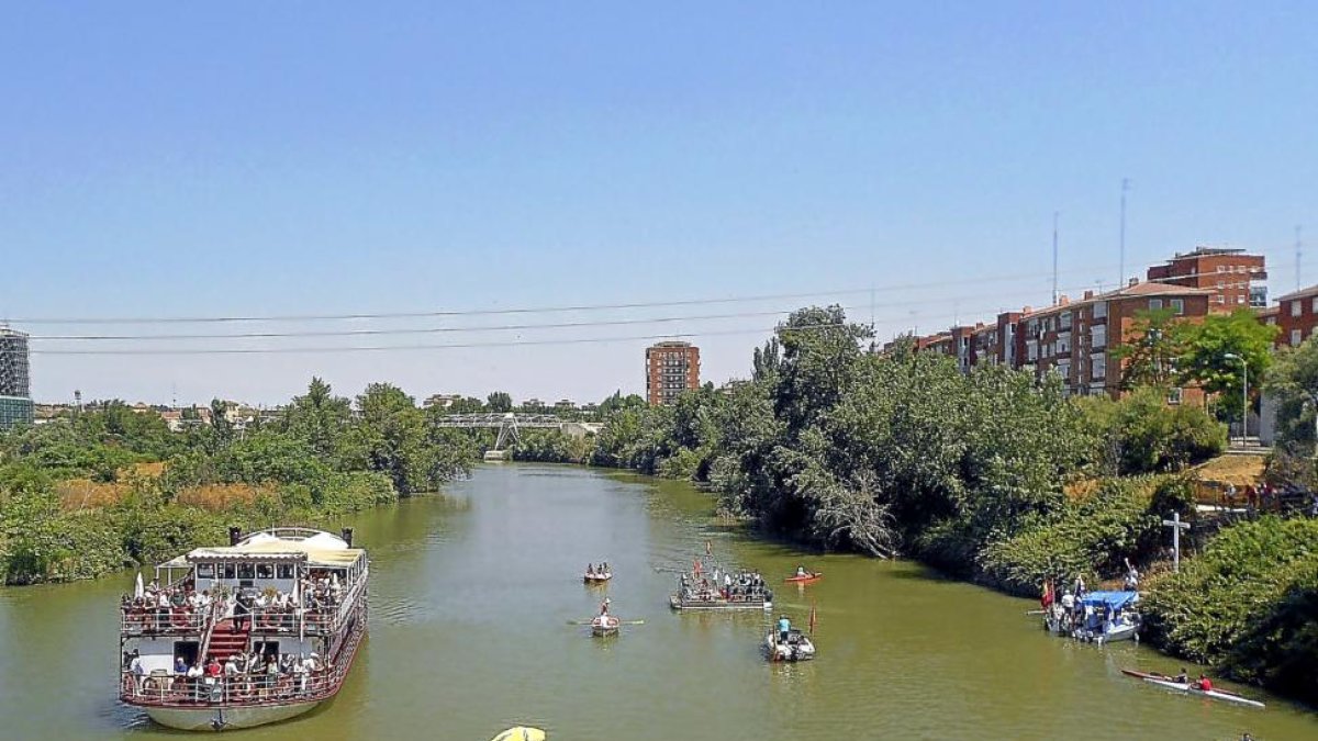 El ‘Leyenda del Pisuerga’ acompaña ayer a un grupo de embarcaciones participantes en la procesión fluvial.-ICAL