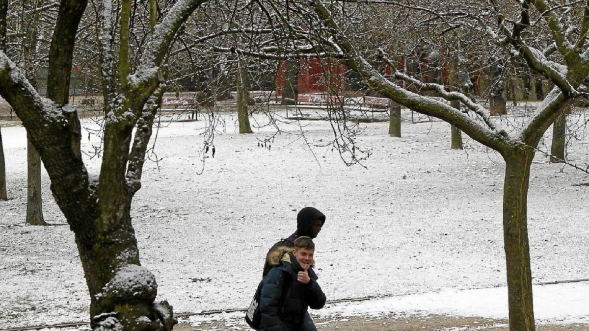 Dos chicos atraviesan un parque del barrio de Parquesol cubierto con una fina capa de nieve, ayer, a primera hora de la mañana-J. M. LOSTAU