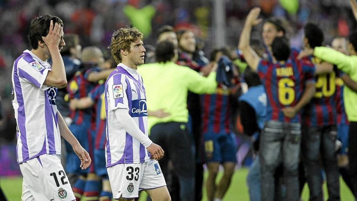 Sereno y Keko, cabizbajos tras el descenso (2009-2010) mientras el Barça celebra el título.-MONTSE ÁLVAREZ