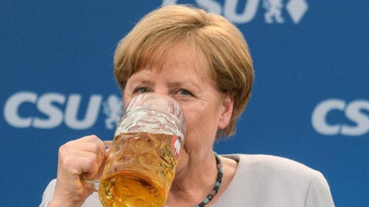 La cancillera alemana bebe una jarra de cerveza tras participar en un mitin en Múnich.-MATTHIAS BALK / AFP
