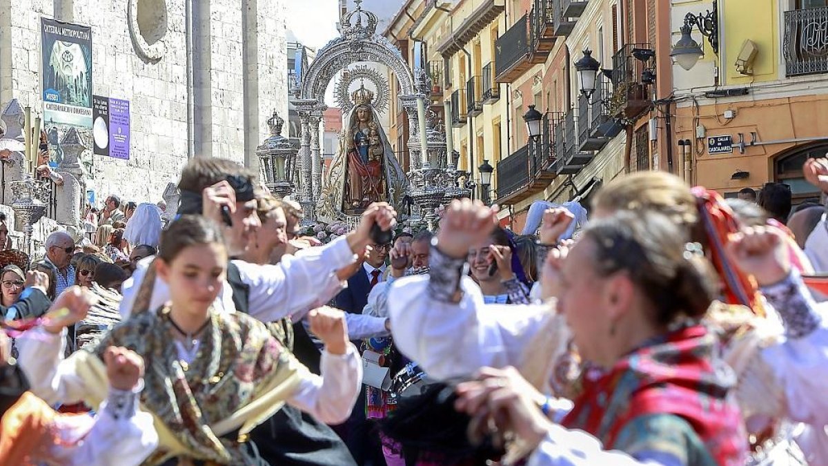 Varios danzantes bailan durante la procesión, con la Virgen de San Lorenzo de fondo.-J. M. LOSTAU