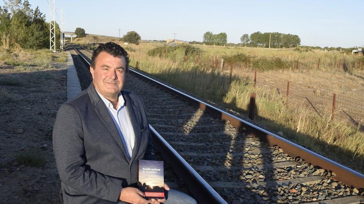 Paco Cañamero posa con su libro Aquella mañana de diciebre en las vías de tren donde tuvo lugar el accidente ferroviario.-ARGICOMUNICACIÓN