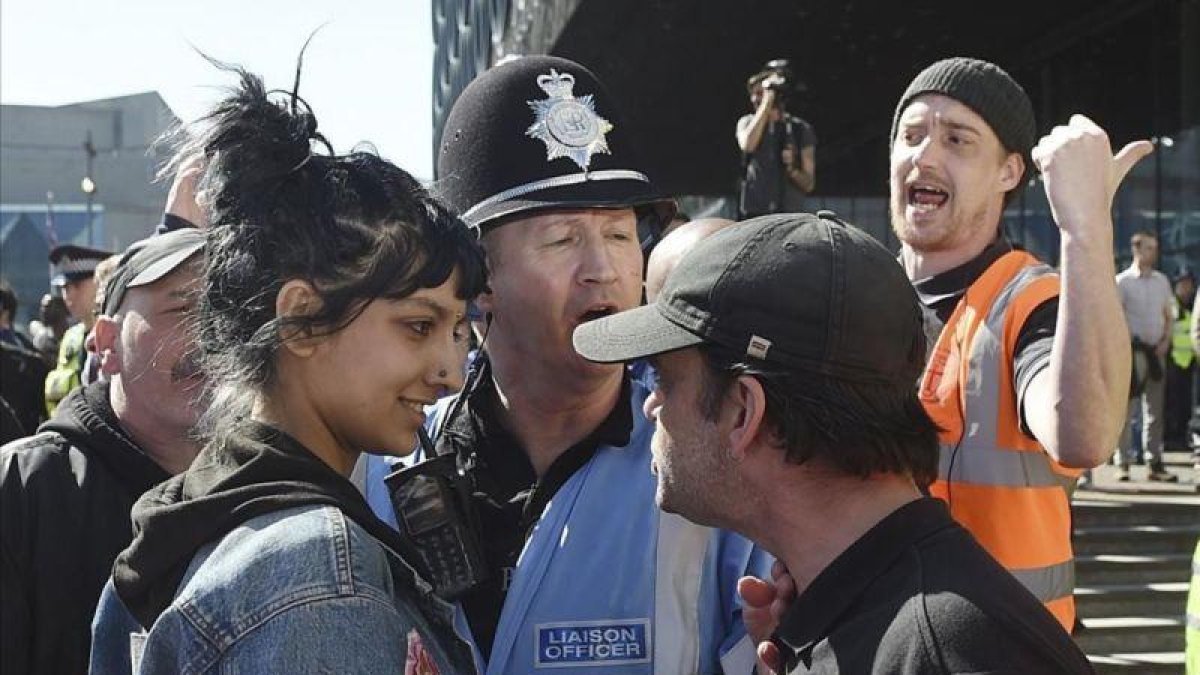 La joven Saffiyah Khan se encara con uno de los meimbros del grupo británico de extrema derecha Liga de Defensa Inglesa (EDL), en su siglas en inglés, en Birmingham el pasado 8 de abril.-AP / JOE GIDDENS