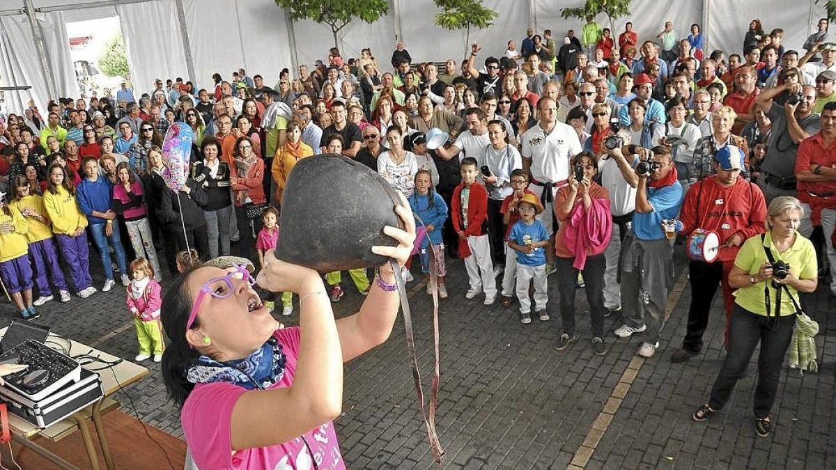 Una joven se divierte en el concurso de beber en bota de la localidad vallisoletana de Olmedo.-EL MUNDO