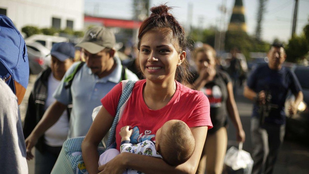 Joven participante en la caravana sostiene a un niño-Rodrigo Sura / EFE