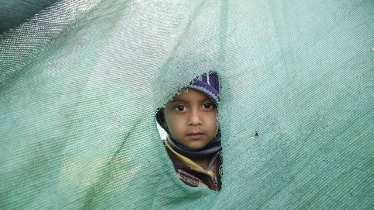Una niña mira desde el agujero de una tienda en Katmandú, en el Nepal.-Foto:   EFE / NARENDRA SHRESTHA