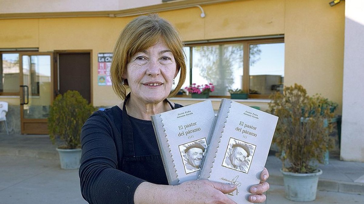 Ascensión, a la puerta del restaurante con el libro que cuenta la historia de su padre, Justo Peña.-ARGICOMUNICACIÓN