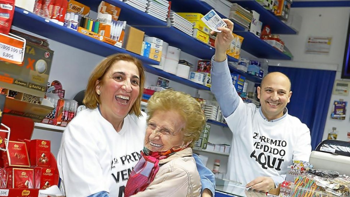 Leonor se entera en el establecimiento de que su décimo tiene premio, en compañía de los hermanos Pilar y Juan Carlos Arribas.-J. M. LOSTAU