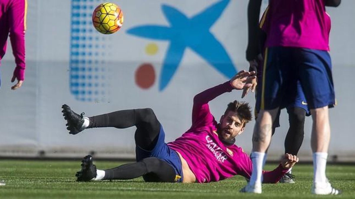 Piqué persigue el balón en el rondo durante el entrenamiento del Barça previo al duelo contra el Granada.-JORDI COTRINA