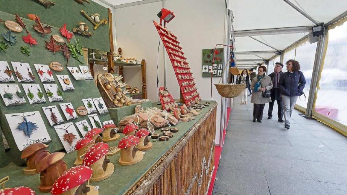 Visitantes contemplan los puestos de la XII Feria de Artesanía de Navidad, inaugurada ayer en la Plaza de Portugalete de Valladolid.-Pablo Requejo