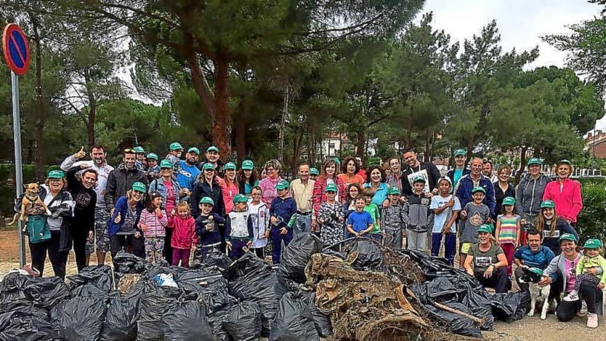 Los participantes en la recogida de basuras de Boecillo posan detrás de algunos de los residuos-EL MUNDO