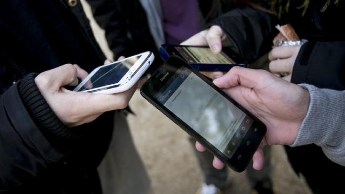 Foto de archivo de unos usuarios utilizando los teléfonos móviles. - E.M.