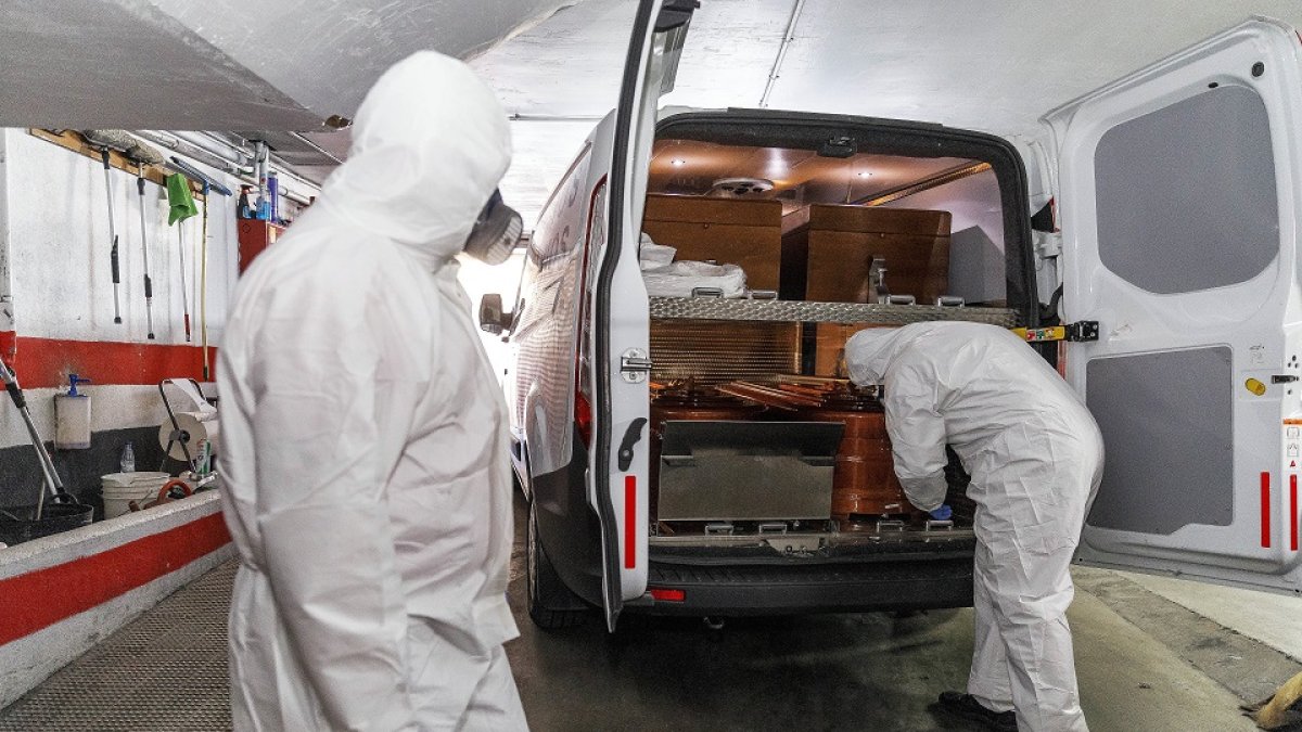 Dos trabajadores de la funeraria Santa Teresa de Segovia, en una imagen de archivo en plena primera ola de la pandemia durante el mes de abril. / ICAL