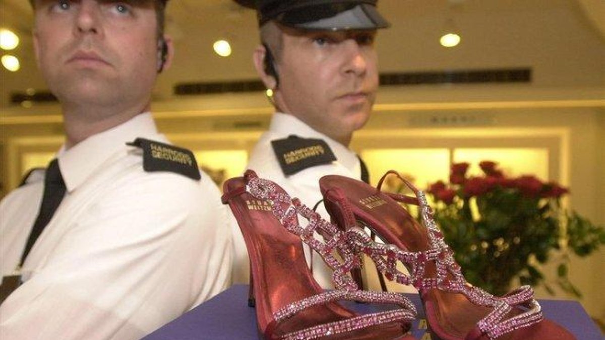 Guardias de seguridad custodian unos zapatos con rubís y platino valorados en 1,47 millones de euros, en Harrods.-EPA