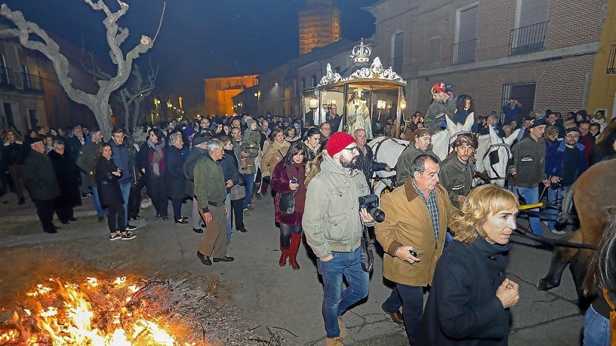 Vecinos y visitantes acompañan el carruaje que transporta a la Virgen de la Concepción, conducido por las mulas, junto a las tradicionales hogueras.-J.M. LOSTAU