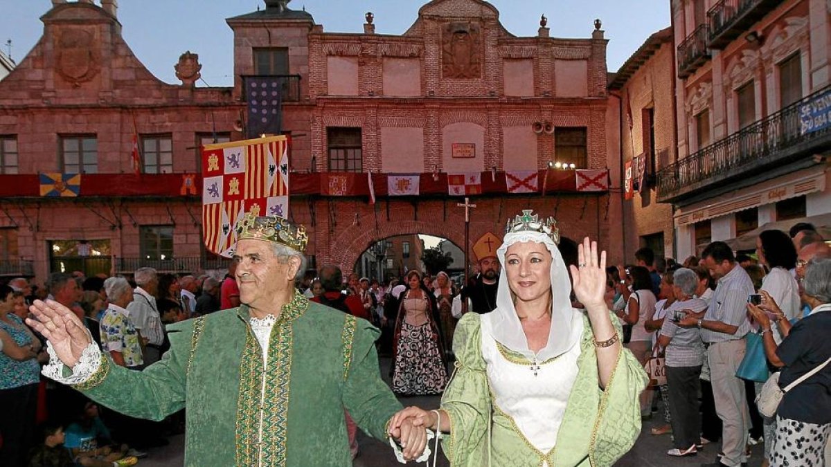 Dos actores ataviados al modo de los Reyes Católicos saludan en uno de los desfiles de una edición anterior.-J. M. LOSTAU