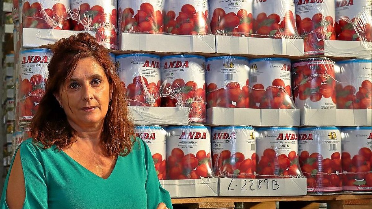 Milagros Anda, administradora  de la conservera Andas, posa junto a un palé de latas.-J. L. C.