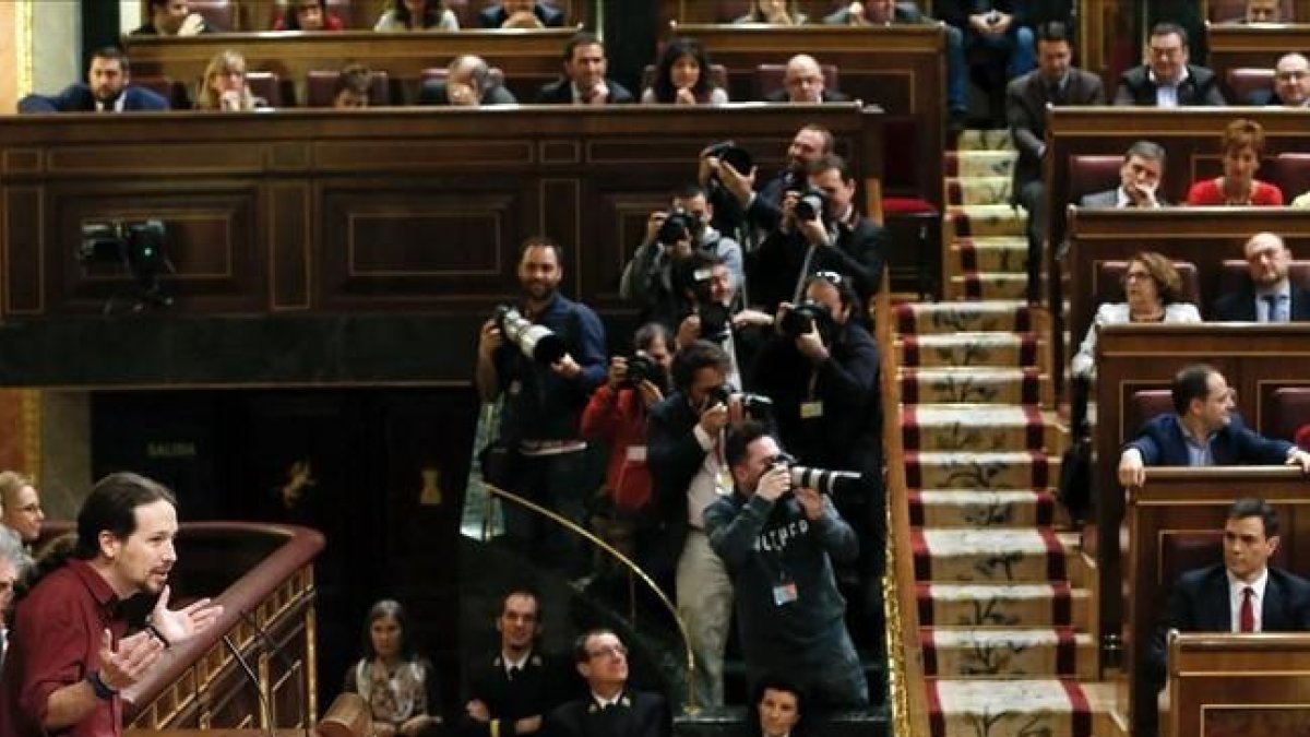 Pablo Iglesias se dirige al hemiciclo en la segunda sesión del debate de investidura con Pedro Sánchez sentado en su escaño.-EFE / BALLESTEROS