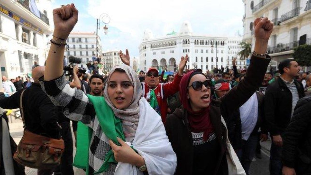 Ciudadanos argelinos gritan consignas y ondean banderas nacionales durante una protesta contra el presidente interino, Abdelkader Bensalah, en Argel.-MOHAMED MESSARA (EFE)