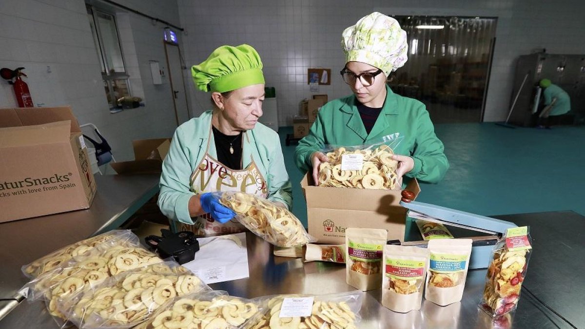 Trabajadoras de una industria agroalimentaria empaquetan snacks en una foto de archivo. E. M.