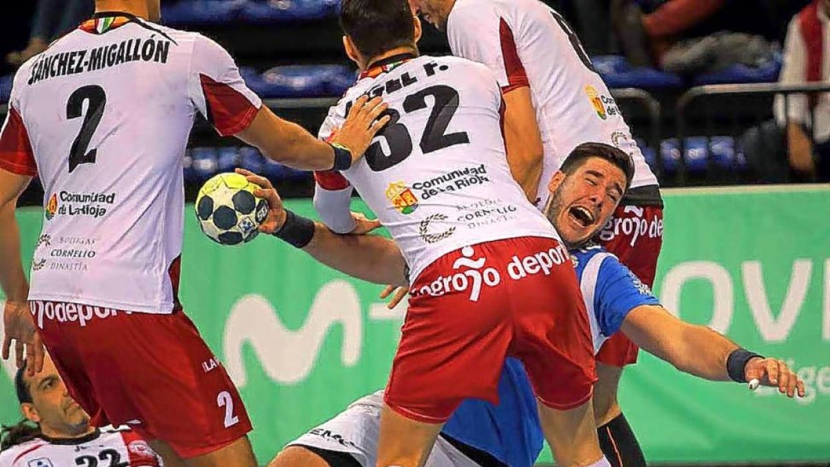 Abel Serdio, autor de tres goles, intenta zafarse de la férrea defensa del BMLogroño.-PHOTODEPORTE