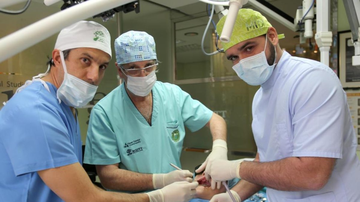 El doctor vallisoletano Antonio Rey (C), creador de la técnica MIDI de implante dental, junto a los doctores Rodrigo Santamarta(I) de Valencia y Darío Castro(D) de Canarias, durante una intervención en la clínica de Valladolid.-ICAL