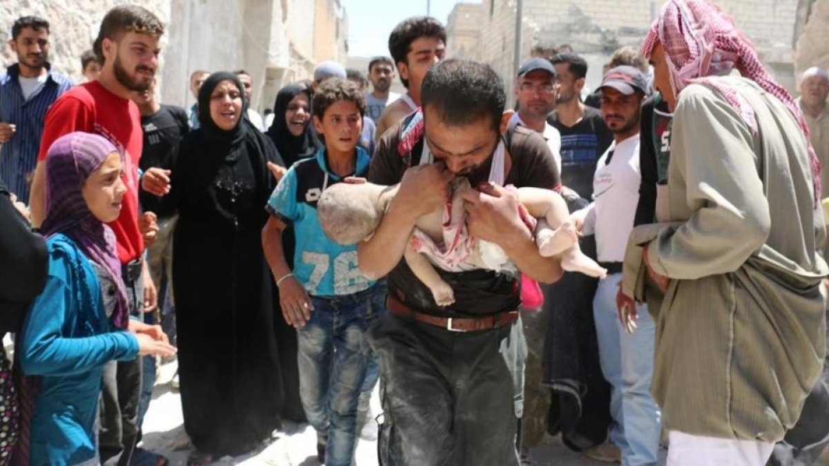 Un hombre sostiene el cuerpo sin vida de su hijo en brazos tras uno de los bombardeos en el barrio rebelde de Al-Marjah, en el norte de Alepo, este domingo.-AFP / AMEER ALHALBI