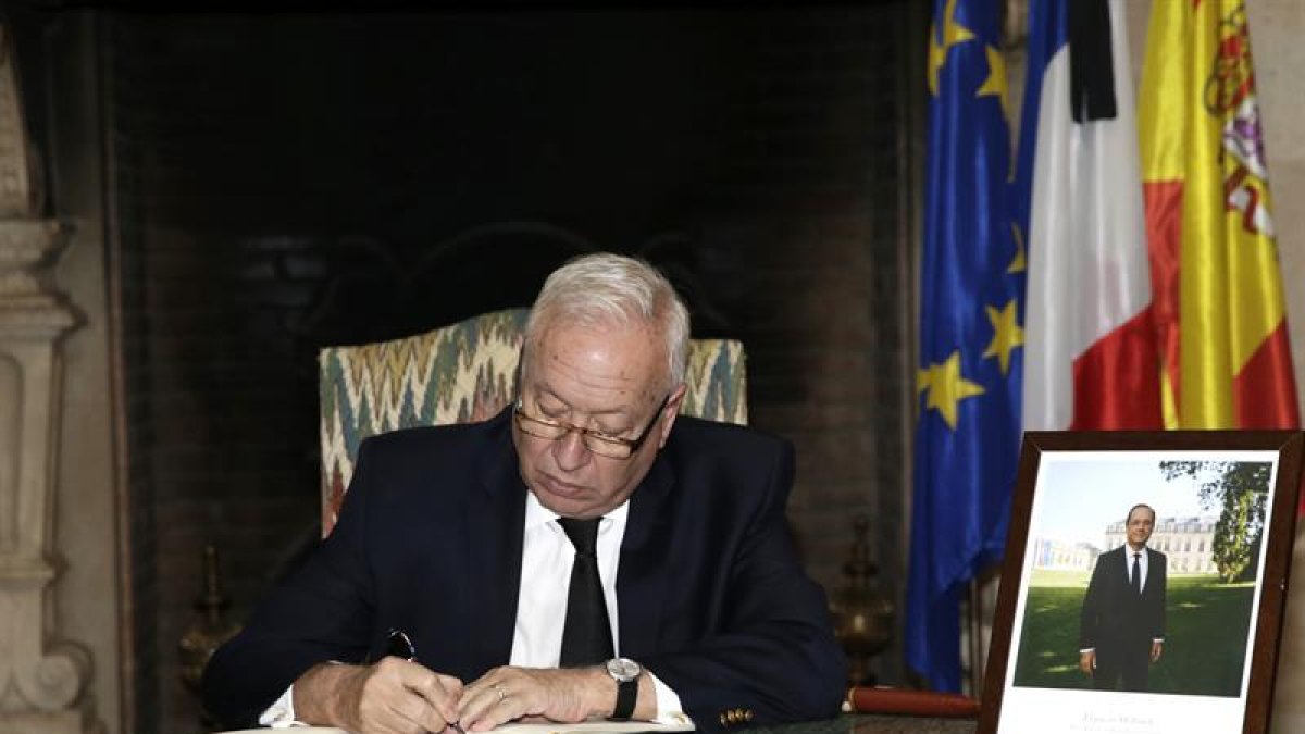 El ministro de Asuntos Exteriores, José Manuel García-Margallo, firma en el libro de condolencias instalado en el vestíbulo de la residencia del embajador de Francia en España, Yves Saint-Geours, tras los atentados terroristas de ayer en París.-EFE/Zipi