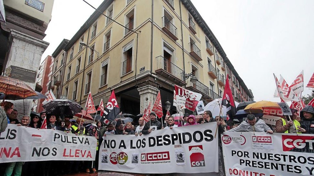 Participantes en la concentración contra el cierre de Lauki y Dulciora sostienen pancartas reivindicativas bajo una lluvia insistente, ayer en la Plaza de Fuente Dorada.-JOSÉ C. CASTILLO