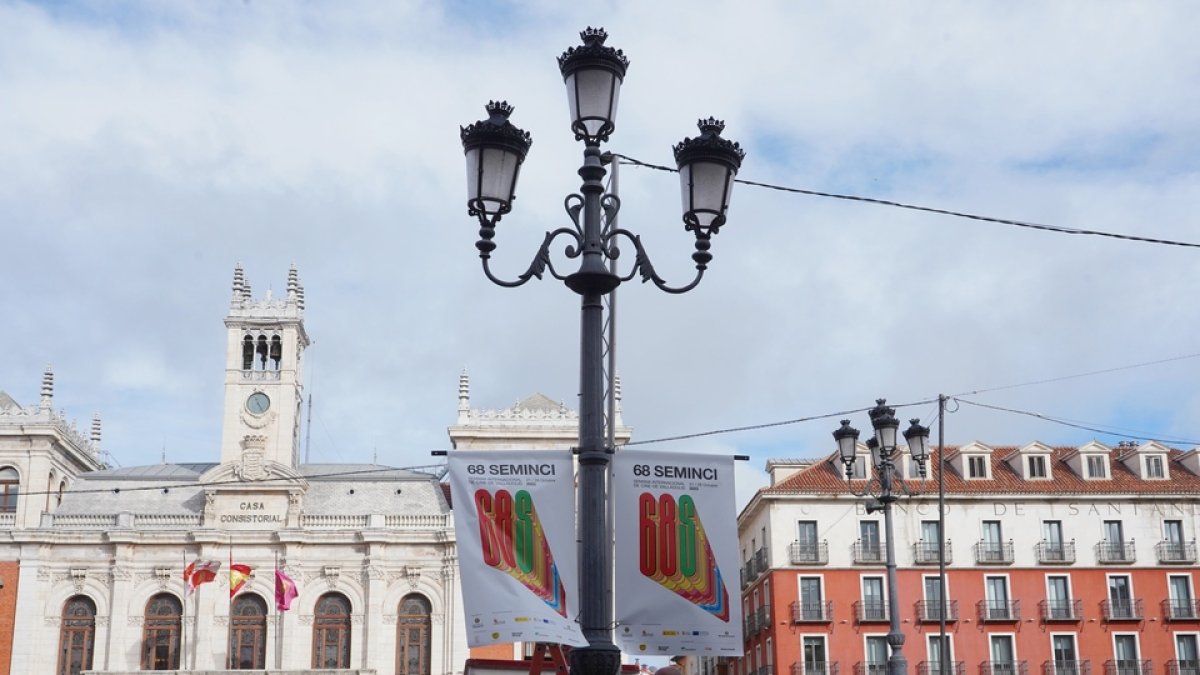 Operarios junto a lonas publicitarias de la semana internacional de cine, Seminci, en la plaza Mayor. / ICAL